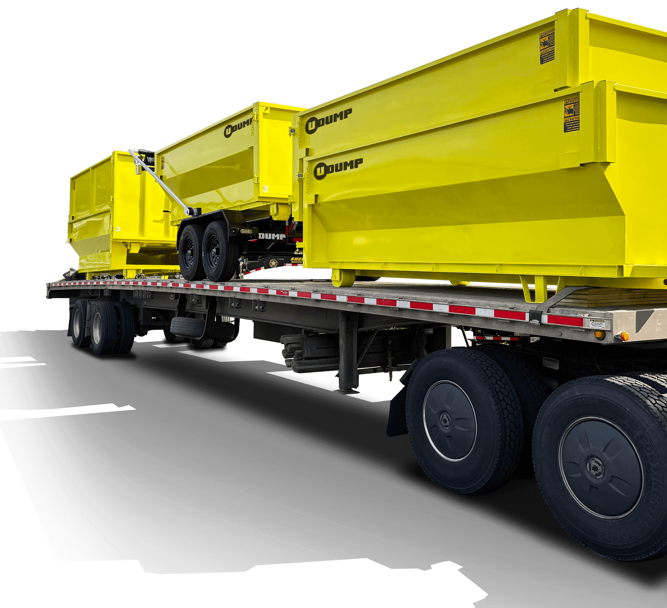 Flatbed truck carries two yellow dump trailers with wheels, positioned for transport.