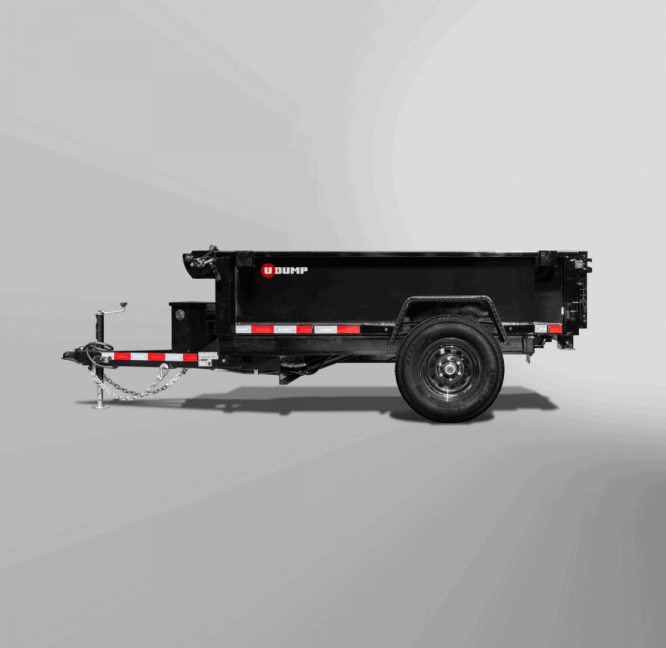 The Pro-Heavy Low-Profile Dump Trailer, a black utility model with a single axle, chains, and a hitch, is set against a plain grayscale background.